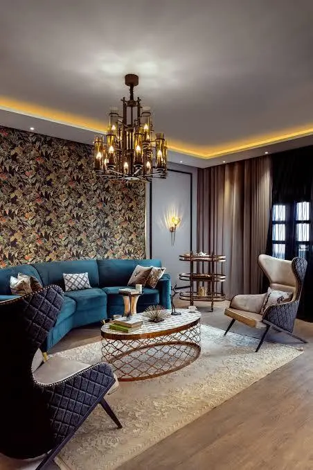 Living room with blue seating, patterned wall and warm lighting