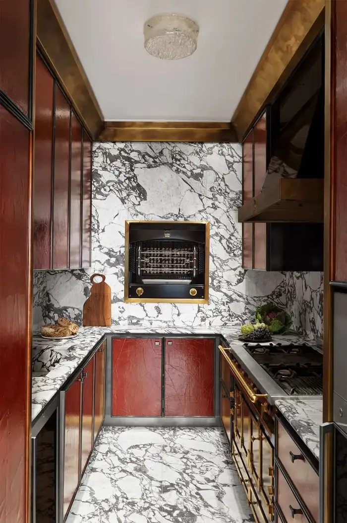 Narrow kitchen with wood cabinets and stone-patterned work surfaces